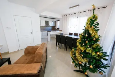 a christmas tree in a living room next to a kitchen at Twin House in Ognyanovo