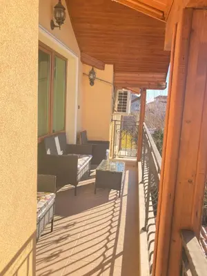 a balcony with chairs and a couch on a house at Къща за гости Мегдана in Sopot