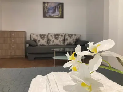 a living room with a couch and white flowers at Къща за гости Мегдана in Sopot