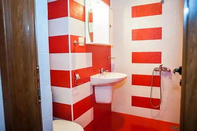 a bathroom with a red and white striped wall at Къща за гости Мегдана in Sopot