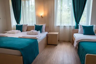 two beds in a room with blue curtains at Youth Centre Plovdiv in Plovdiv