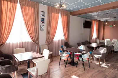 a restaurant with tables and chairs and windows at Youth Centre Plovdiv in Plovdiv
