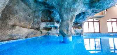 a large swimming pool with a rock wall at Valentina Castle in Ognyanovo