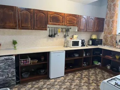 a kitchen with wooden cabinets and a white refrigerator at Atanasovata Kashta in Govedartsi