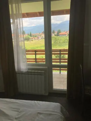 a bedroom with a bed and a window with a view at Atanasovata Kashta in Govedartsi