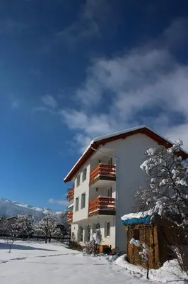 a white building with snow on the ground at Atanasovata Kashta in Govedartsi