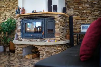 a large stone fireplace with a tv in it at Atanasovata Kashta in Govedartsi
