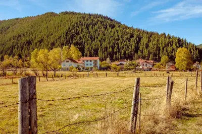 a fence in a field in front of a mountain at Atanasovata Kashta in Govedartsi