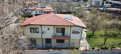 a small house with a red roof on a hill at Kot Garden Guest House in Sapareva Banya