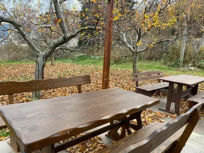 a wooden table and two benches in a park at Kot Garden Guest House in Sapareva Banya