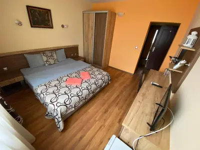a bedroom with a bed and a wooden floor at Kot Garden Guest House in Sapareva Banya
