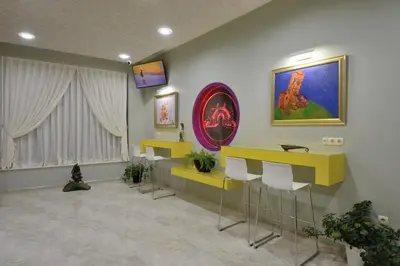 a waiting room with yellow tables and stools at Hotel Hello Hissar in Hisarya