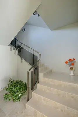 a staircase with a glass railing and a vase of flowers at Hotel Hello Hissar in Hisarya