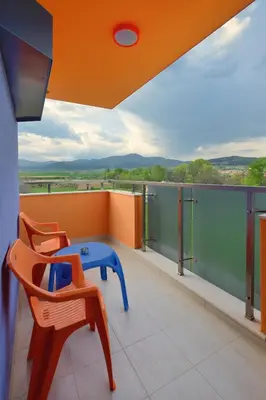 a balcony with a blue table and chairs on it at Hotel Hello Hissar in Hisarya