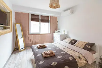 a bedroom with a large bed and a mirror at Domus Apartments City Center with Parking in Plovdiv