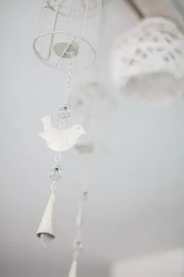 a bird chime hanging from a white wall at Domus Apartments City Center with Parking in Plovdiv