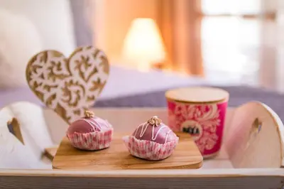 a tray with two cupcakes on a table with hearts at Domus Apartments City Center with Parking in Plovdiv