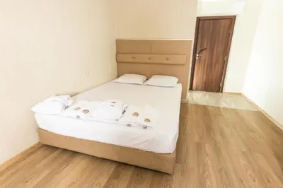 a bed with white sheets and pillows in a room at Hotel Nikol in Dolna Banya
