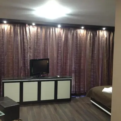 a room with a bed and a flat screen tv at Studio Mountain Dreams Deluxe in Sapareva Banya