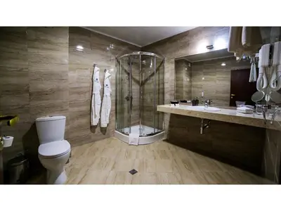 a bathroom with a shower and a toilet and a sink at Park Hotel and SPA Vella Hills in Velingrad