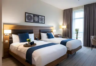 a hotel room with two beds and a table at Premier Sofia Airport Hotel in Sofia