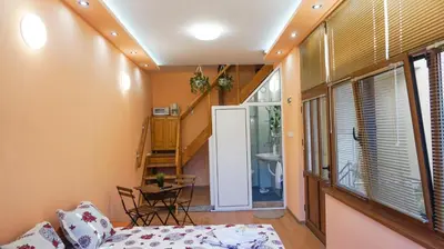 a room with a bed and a staircase and a table at Pamir Guest House in Shipkovo