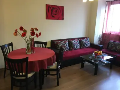 a living room with a red table and a couch at Oscar Wilde Apartment in Sofia