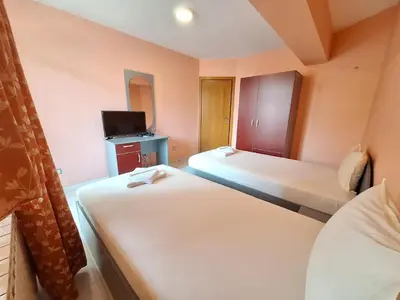 a small room with two beds and a tv at Hotel Ertancom in Blagoevgrad