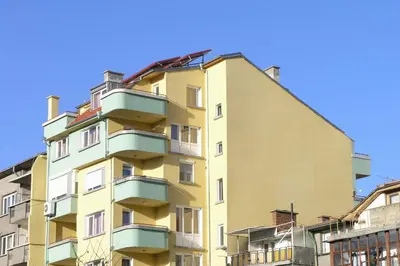 a tall yellow building with balconies on it at Hotel Ertancom in Blagoevgrad
