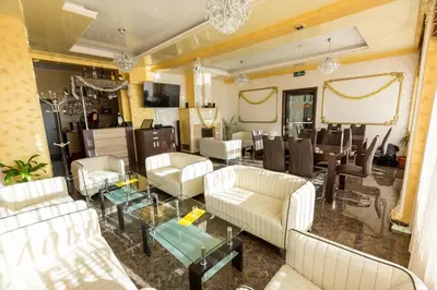 a living room with white furniture and a dining room at Hotel Kristal in Dospat