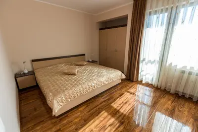 a bedroom with a bed and a wooden floor at Hotel Kristal in Dospat