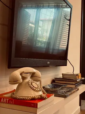 a telephone sitting on top of a book in front of a tv at The Clock house in Samokov
