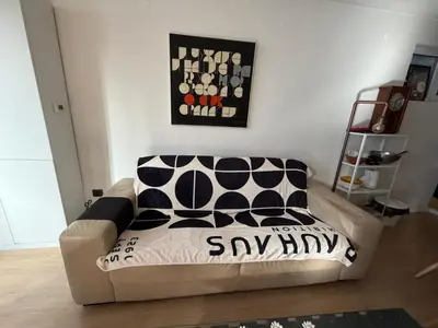 a couch in a living room with a black and white pillow at The Clock house in Samokov