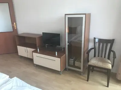 a bedroom with a dresser and a mirror and a chair at Flora Apartment 619 in Borovets