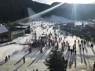 a group of people skiing down a snow covered slope at Flora Apartment 619 in Borovets