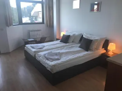 a bedroom with a large bed with white sheets and pillows at Flora Apartment 619 in Borovets