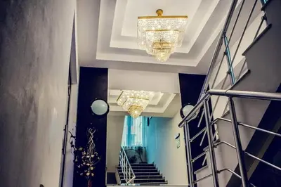 a hallway with chandeliers and a staircase with blue walls at Zdravets SPA Hotel in Velingrad