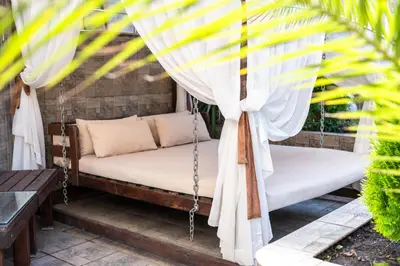 a swing on a patio with a curtain at Zdravets SPA Hotel in Velingrad