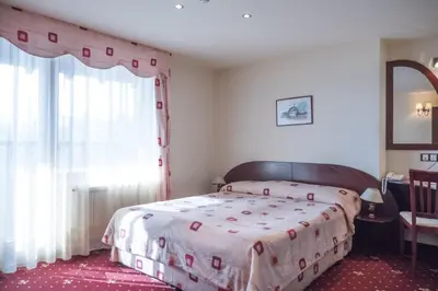a bedroom with a large bed with a large window at Martin Club Hotel in Bansko