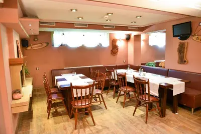 a restaurant with tables and chairs in a room at Martin Club Hotel in Bansko