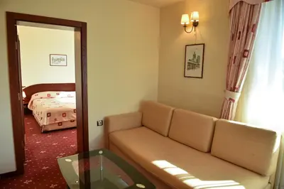 a living room with a couch and a mirror at Martin Club Hotel in Bansko