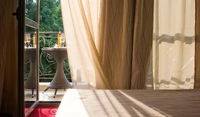 a bedroom with a bed and a window with a balcony at Famous House in Plovdiv