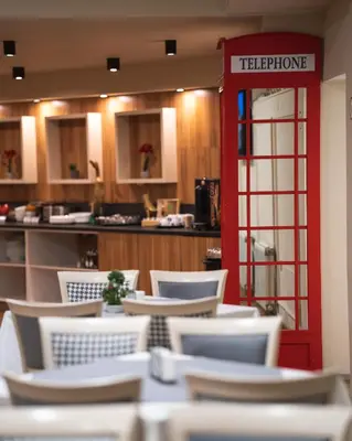 a restaurant with a red telephone booth and chairs at Hotel BLVD 7 in Plovdiv