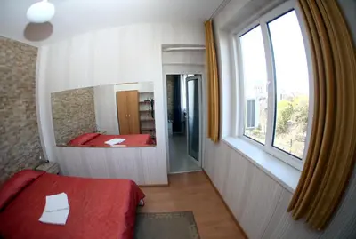 a bedroom with a red bed and a mirror at COLORED HOUSE Apartments in Sofia