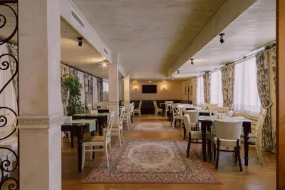 a dining room with tables and chairs and a tv at Green Life Bansko in Bansko