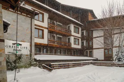 a building with a sign on it in the snow at Green Life Bansko in Bansko