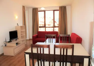 a living room with a table and a red couch at PM Services Semiramida Apartments in Borovets