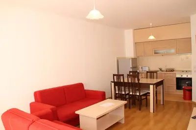 a living room with a red couch and a table at PM Services Semiramida Apartments in Borovets