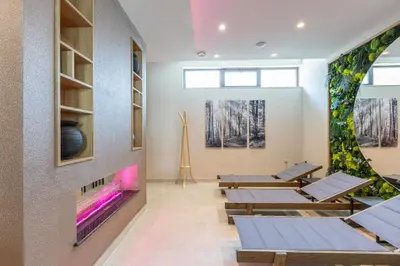 a room with tables and a wall with a fireplace at Spa Hotel Persenk in Devin
