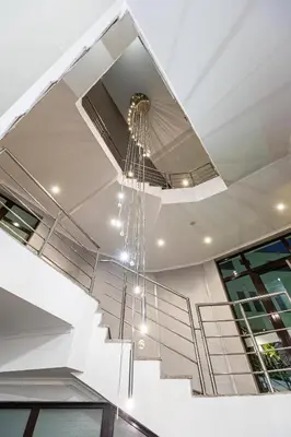 a chandelier hangs from the ceiling of a staircase at Spa Hotel Persenk in Devin